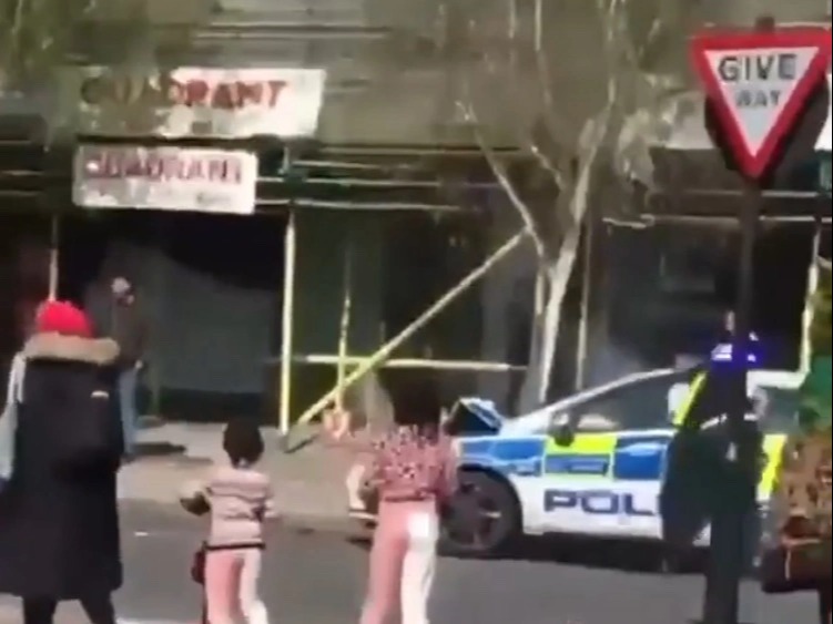 A Shocking Video Shows A Garbage Truck Reversing At Speed As A Police Patrol Car Rams On A London Street. The Stunned Spectators Were Only A Few Meters Away From The Collision.