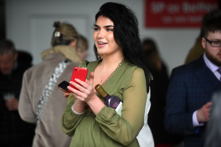 Aintree Revelers Get Into The Party Spirit At The Grand National As Racers Enjoy Booze And Plucky Frosts. One Girl Held A Bottle Under Her Arm, Watching What Was Happening.