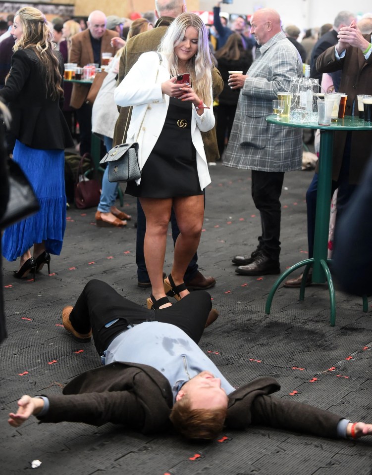 Aintree Revelers Get Into The Party Spirit At The Grand National As Racers Enjoy Booze And Plucky Frosts. It All Became Too Much For One Man Who Lay Down On The Carpet After Spilling It On His Shirt.
