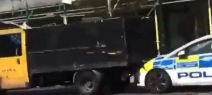 A Shocking Video Shows A Garbage Truck Reversing At Speed As A Police Patrol Car Rams On A London Street. The Police Moved Back As The Truck Headed Towards Them, But They Collided