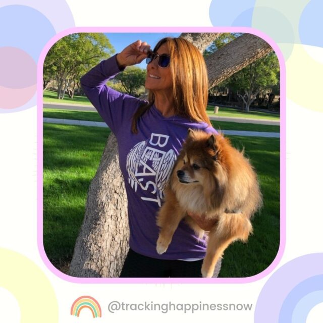 The woman is holding the dog.